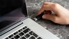Podłączanie pendrive USB do laptopa na biurku z marmurowym blatem