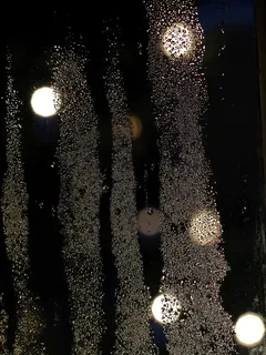 Krople wody na szkle nocą, scena wody i światła