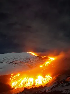 Góra w ogniu i lawie pod nocnym niebem