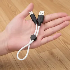 Krótki kabel USB do ładowania trzymany na dłoni, przewód biały, końcówka USB i USB-C.