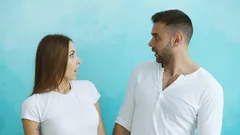 Młoda para patrzy na siebie z zaskoczeniem i radością w pomieszczeniu